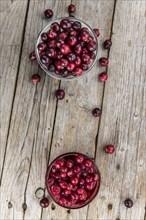 Vintage wooden table with Cranberries (preserved) (selective focus, close-up shot)