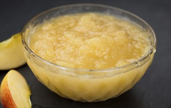 Homemade Applesauce (selective focus, close-up shot) on vintage background with some fresh fruits