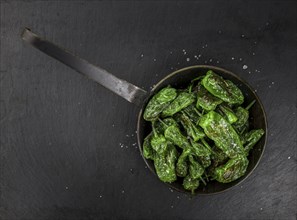 Portion of Pimientos de Padron on a rustic slate slab, selective focus, close-up shot