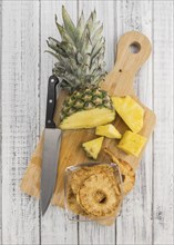 Pineapple rings (dried) on rustic wooden background as close-up shot