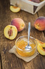 Peach Jam on an old wooden table as detailed close-up shot, selective focus