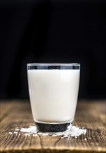 Wooden table with Rice Milk (detailed close-up shot, selective focus)