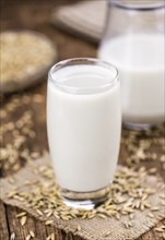 Wooden table with Oat Milk (detailed close-up shot, selective focus)