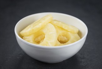 Preserved Pineapple Rings on a vintage slate slab as detailed close-up shot, selective focus