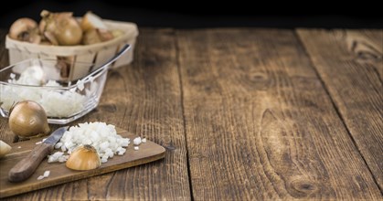 White Onions (dices) as high detailed close-up shot on a vintage wooden table, selective focus