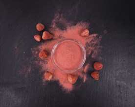 Portion of Strawberry powder as detailed close up shot on a slate slab, selective focus