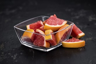 Portion of sliced Grapefruits on an old slate slab (selective focus, close-up shot)