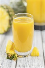 Fresh made Pineapple Juice on an old and rustic wooden table, selective focus, close-up shot