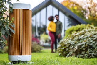 Modern air purifier in a garden, blurred view of a couple in the background, AI generated, AI