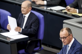 CDU parliamentary group leader Friedrich Merz, right, speaks in the Bundestag, in the background is