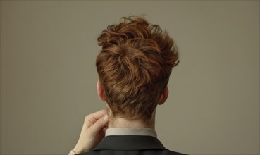 A man with auburn hair on neutral background, back view, AI generated