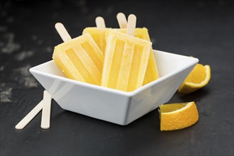 Orange Popsicles (selective focus, close-up shot) on a vintage background