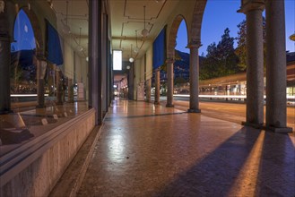 Shopping Street with Shops and Reflection Below Archway in Dusk and Long Exposure in City of