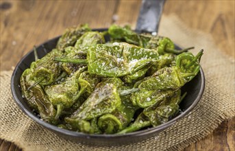 Pimientos de Padron on a vintage background as detailed close-up shot, selective focus