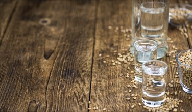 Wooden table with Wheat Liqueur (detailed close-up shot, selective focus)