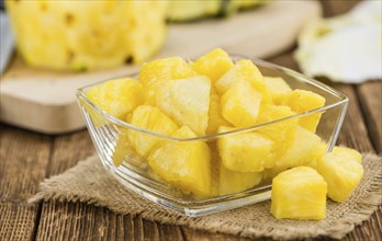 Sliced Pineapple on rustic wooden background as close-up shot