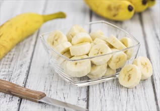 Sliced Bananas on an old wooden table as detailed close-up shot, selective focus