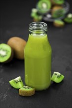 Some fresh homemade Kiwi Smoothies on a slate slab (close-up shot, selective focus)