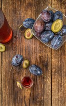 Plum Liqueur on rustic wooden background as close-up shot