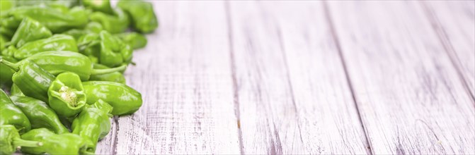 Raw Pimientos on rustic wooden background as close-up shot