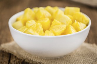 Sliced Pineapple on an old wooden table as detailed close-up shot, selective focus