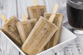 Some homemade Cola Popsicles (close-up shot, selective focus) on vintage background