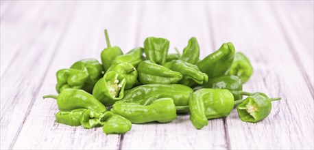 Raw Pimientos on rustic wooden background as close-up shot