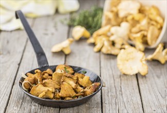 Fried Chanterelles on an old wooden table as detailed close-up shot, selective focus