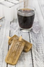 Some homemade Cola Popsicles (close-up shot, selective focus) on vintage background