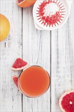 Vintage wooden table with a portion of freshly squeezed Grapefruit Juice (selective focus)