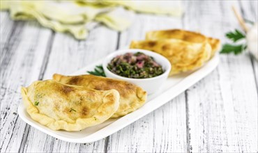 Portion of healthy Empanadas on an old wooden table (selective focus, close-up shot)