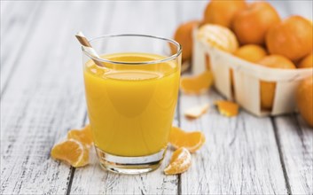 Homemade Tangerine Juice (close-up shot, selective focus) on a rustic background