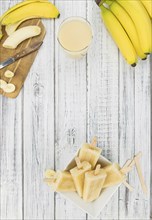 Homemade Banana Popsicles on a vintage background (close-up shot, selective focus)