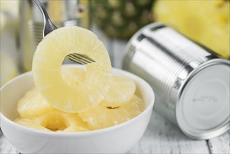 Preserved Pineapple Rings as high detailed close-up shot on a vintage wooden table, selective focus