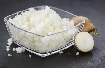 Some White Onions (dices) on a slate slab as detailed close-up shot, selective focus