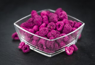 Dried Raspberries on a vintage slate slab as detailed close-up shot, selective focus