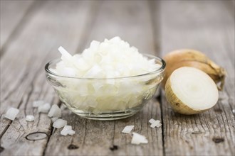 Chopped white onions on an old wooden table as detailed close-up shot, selective focus