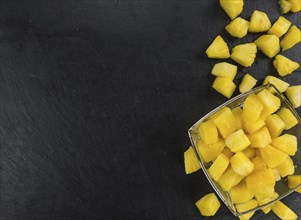 Portion of Pineapple (sliced) on a rustic slate slab, selective focus, close-up shot