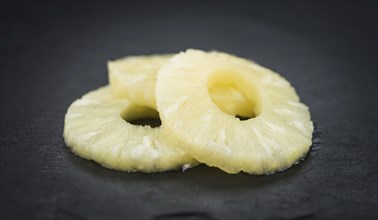 Some fresh Preserved Pineapple Rings on a vintage slate slab, selective focus, close-up shot