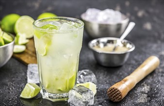 Caipirinha made with fresh limes, ice and sugar as close-up shot