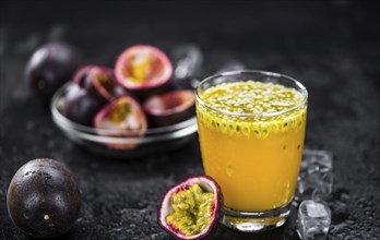 Portion of healthy Maracuja Juice on a slate slab (selective focus)