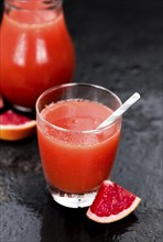 Slate slab with freshly squeezed Grapefruit Juice (selective focus, close-up shot)