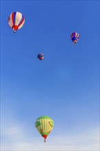 Colorful hot air balloons floating peacefully in a clear blue sky, Belarus, Minsk, Europe