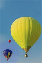 Three colorful hot air balloons floating in a clear blue sky, Belarus, Minsk, Europe