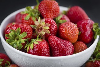 Portion of Strawberries as detailed close up shot on a slate slab, selective focus