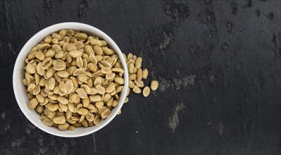 Roasted Peanuts on a vintage slate slab (selective focus, close-up shot)