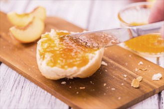 Peach Jam on an old wooden table as detailed close-up shot, selective focus