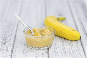 Banana Puree on wooden background (selective focus, close-up shot)