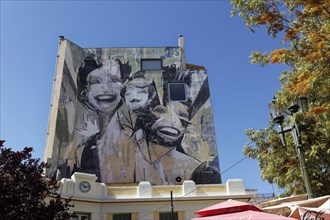 Figure with three different heads, mural by Greek street artist Vasmou, entitled Superman, Psirri