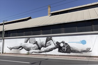 Reclining woman in bikini with diving mask, surreal mural in black and white by Greek street artist